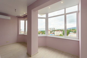 A room in a new building with a fresh renovation. The walls are pink, the floors "under the tree"