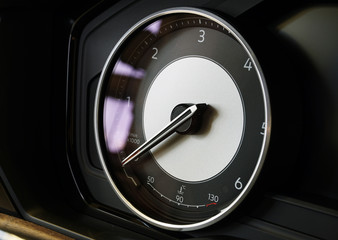 Tachometer with integrated temperature sensor. The arrow indicates zero. Interior of a modern...