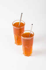 Herbal berry drink sea buckthorn with oregano in a glass on a light background