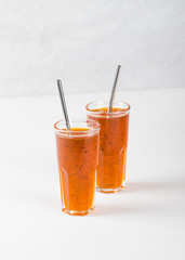 Herbal berry drink sea buckthorn with oregano in a glass on a white background