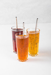 Herbal fruit cocktail in a glass, pineapple with Basil, pomegranate with mint, sea buckthorn with oregano on a light background