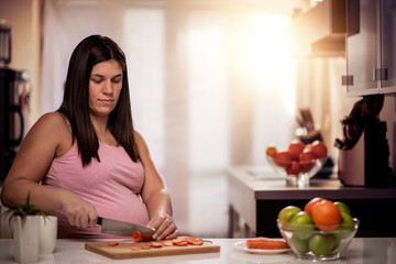 Obraz na płótnie Canvas Pregnant woman preparing healthy food in kitchen.