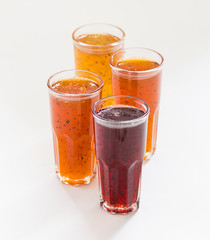 Herbal fruit berry drink in a glass, pineapple with Basil, pomegranate with mint, sea buckthorn with oregano on a white background