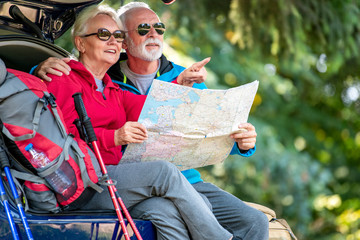 Senior hikers looking at map.