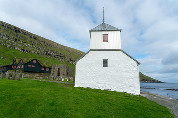 Fototapeta na wymiar Kirkjubøur (Danish: Kirkebø) is the southernmost village on Streymoy, Faroe Islands. The village is located on the south-west coast of Streymoy: Saint Olav's Church