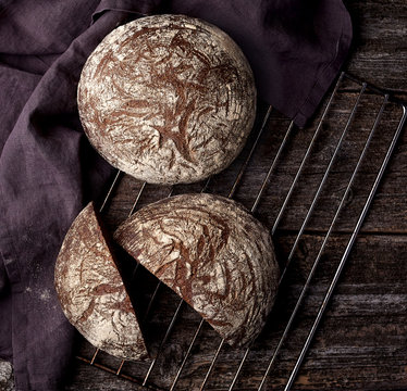 Freshly baked wheat bread, homemade cakes, still life with bread, crisp loaf of bread, still life on a rustic background, top view, rustic bread, roll, loaf.