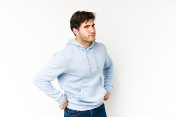 Fototapeta premium Young man isolated on white background frowning face in displeasure, keeps arms folded.