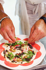 chef making beef carpaccio in the restaurant