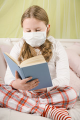 Girl reading a book during quarantine on the bed.