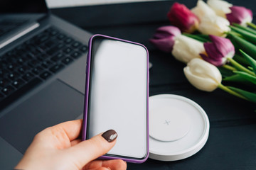 Smartphone in purple case in hand. Electronics.