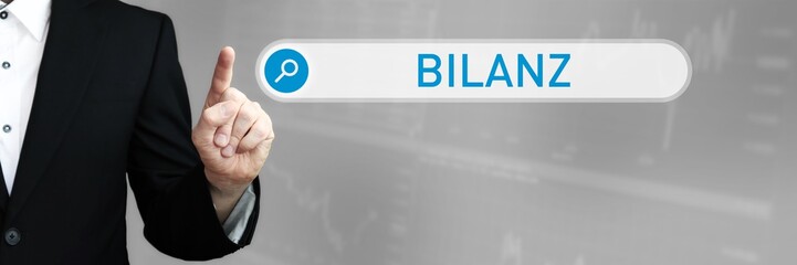 Bilanz. Mann im Anzug zeigt mit dem Finger auf ein Suchfeld. Das Wort Bilanz steht in der Suche....