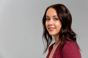 Obraz premium Happy that everything is okay. Portrait of charming friendly caucasian girl smiling cheerfully while standing against gray background, listening order or talking to coworker