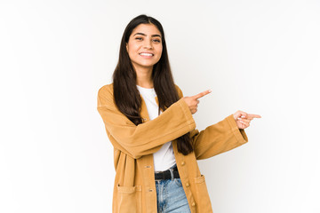 Young indian woman isolated on purple background excited pointing with forefingers away.