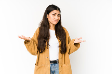 Young indian woman isolated on purple background doubting and shrugging shoulders in questioning...