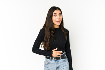 Young indian woman isolated on purple background touches tummy, smiles gently, eating and satisfaction concept.