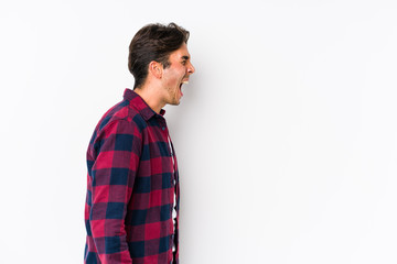 Fototapeta premium Young caucasian man posing in a pink background isolated shouting towards a copy space