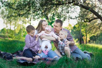Fototapeta premium Family having picnic in countryside. Concept candid happy family and three children.