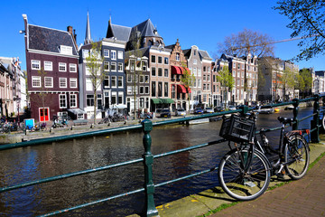 Bicycle lining the famous beautiful canals of Amsterdam under blue skies, Netherlands