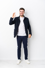 Full body young caucasian man isolated cheerful and confident showing ok gesture.