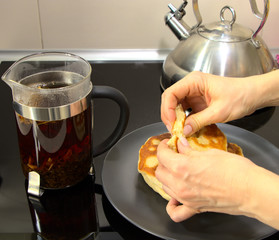 Pita bread in female hands. Breakfast with flour cake and tea. Hot drink in a glass bowl. Hearty breakfast for a vegetarian.