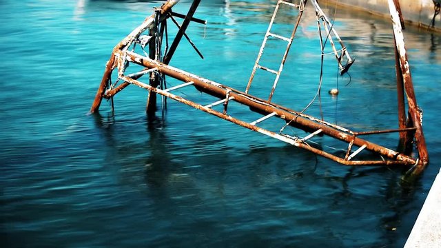 Rusty remains of old sinked fishing ship standing out of water in Umag, Croatia.Umag, Croatia.