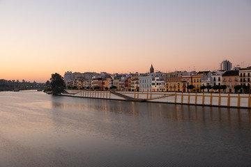 Obraz na płótnie Canvas Barrio sevillano de Triana y río Guadalquivir al amanecer