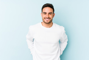 Young caucasian man isolated on blue background happy, smiling and cheerful.