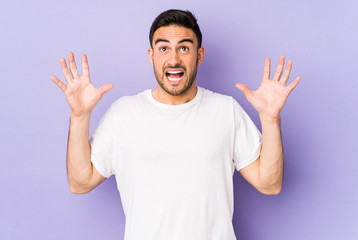 Young caucasian man isolated on purple background screaming to the sky, looking up, frustrated.