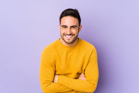 Young caucasian man isolated on purple background laughing and having fun.