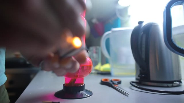 A man smokes cannabis CBD through a water fixture in the kitchen. Exhales smoke into the chamber. Alternative medecine concept.