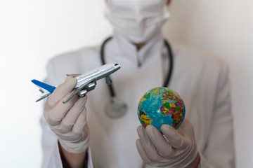 Doctor holding world globe and airplane