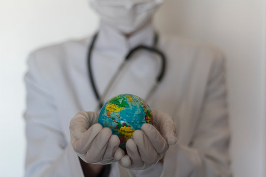 Doctor Holding The World On Hands With Gloves