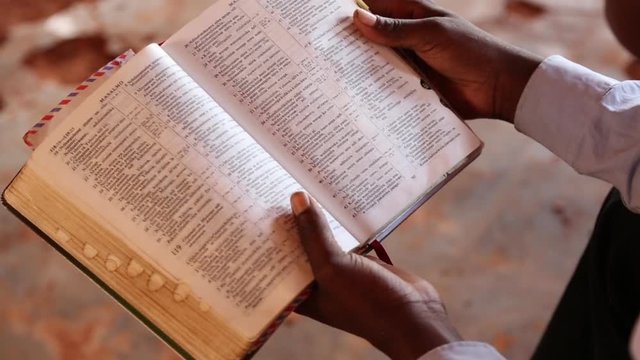 African Man Reads Bible Close Up of Pages