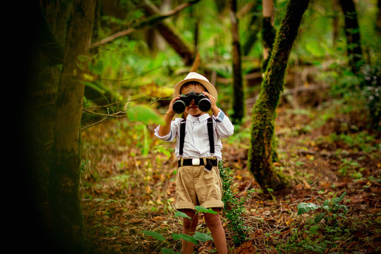 little boy with binocle in the hands and hat ,walks in the Park Safar