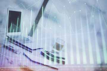 Forex graph hologram on table with computer background. Multi exposure. Concept of financial markets.