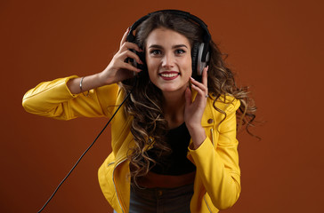 Beautiful, happy girl listening to music with professional headphones
