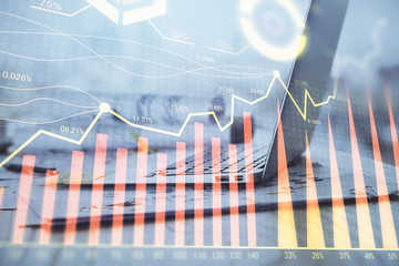 Stock market graph on background with desk and personal computer. Multi exposure. Concept of financial analysis.