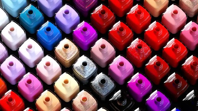 Multi-colored nail polish bottles arranged by shade Seamless animation. 4k HD