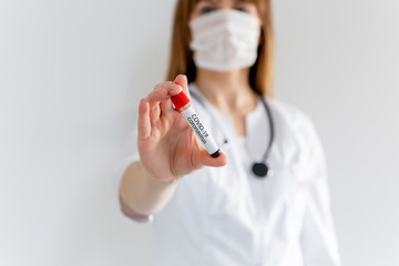 Doctor holding positive blood test of the new coronavirus outbreaks. nCoV blood sample. Originally...
