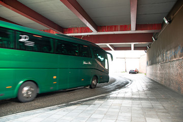 Green bus turning under bridge  © Floren Horcajo
