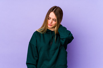 Fototapeta premium Young caucasian woman isolated on purple background having a neck pain due to stress, massaging and touching it with hand.
