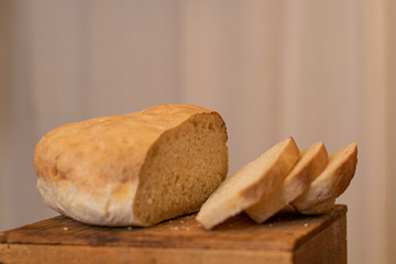 Sliced white bread with crunchy crust. A white background and rustic feel.