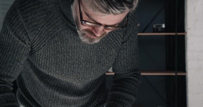 Attractive Middle aged Architect making Blueprints with Pencil and Special Ruler at Office. Looking Serious and Confident. Making Future Building. Having charming Appearance and stylish Eyeglasses.