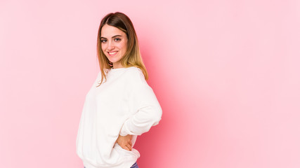 Fototapeta premium Young caucasian woman isolated on pink background confident keeping hands on hips.