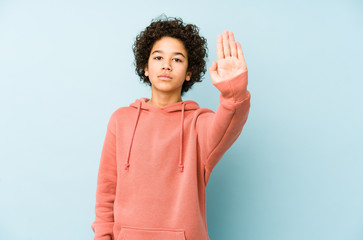 African american little boy isolated standing with outstretched hand showing stop sign, preventing...