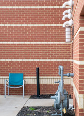 blue chairs outside a brick motel service entrance