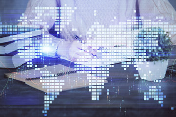 Obraz premium International business hologram over woman's hands taking notes background. Concept of success. Double exposure