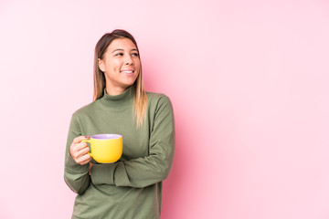 Young caucasian woman holding a coffee smiling confident with crossed arms.