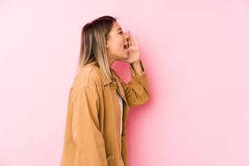 young caucasian woman posing isolated shouting and holding palm near opened mouth.