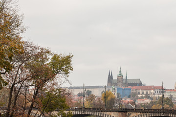 Naklejka premium Panorama of the Old Town of Prague, Czech Republic, in autumn, at fall, with Hradcany hill and the Prague Castle with the St Vitus Cathedral (Prazsky hill) seen from Vltava river. 